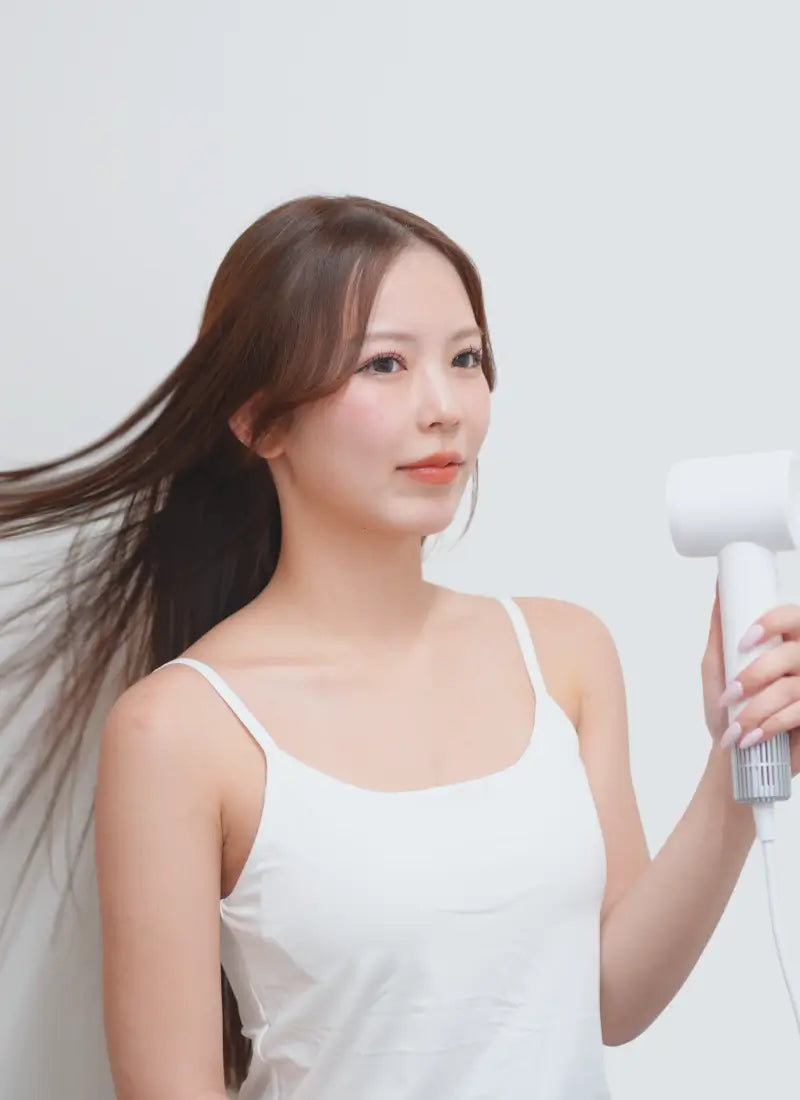 ドライヤーを使用している女性の画像